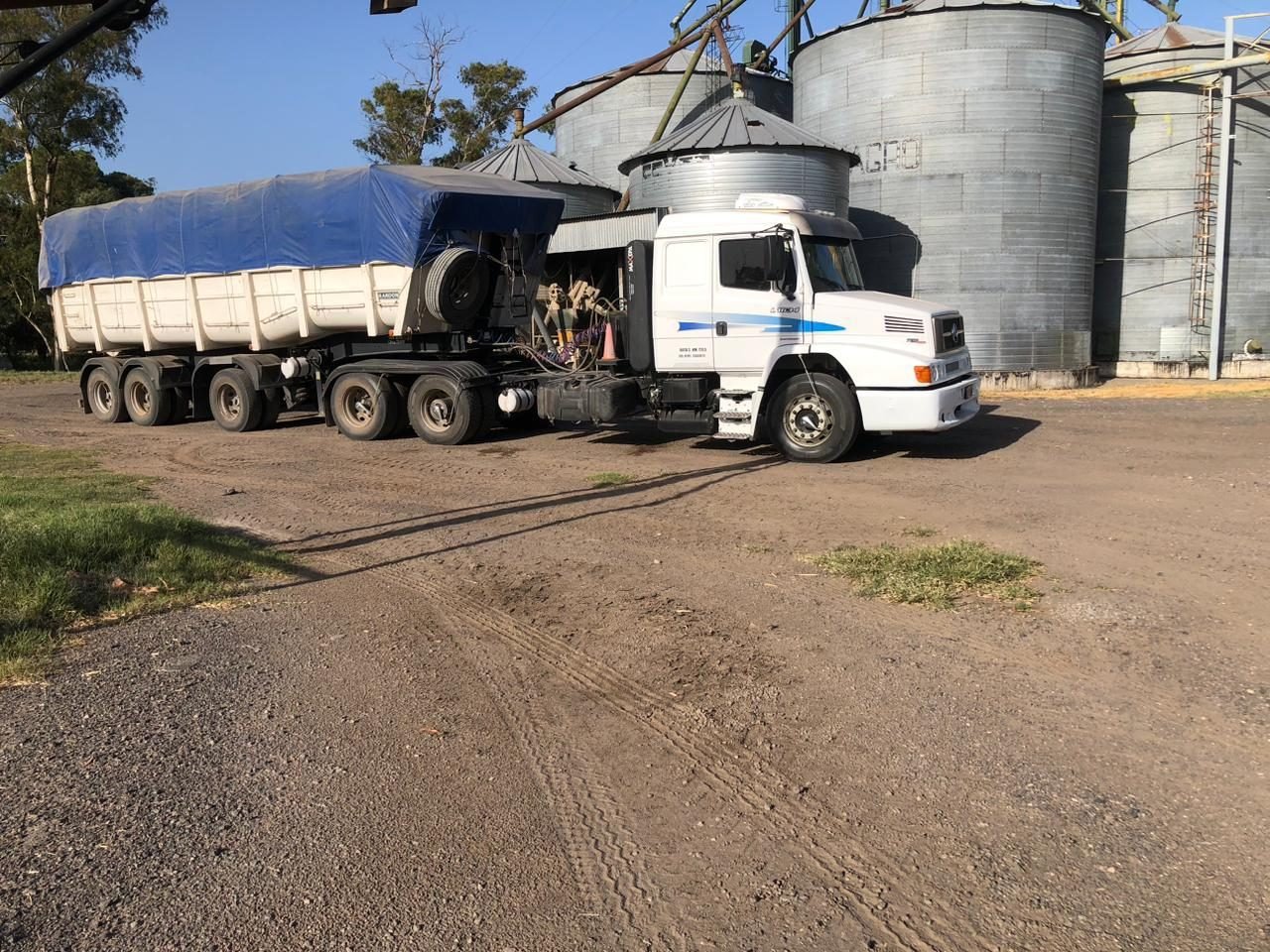 Camión de Lapiru con batea cargando cereal junto a los silos